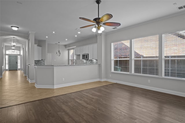 kitchen featuring white cabinets, tile patterned flooring, backsplash, and kitchen peninsula