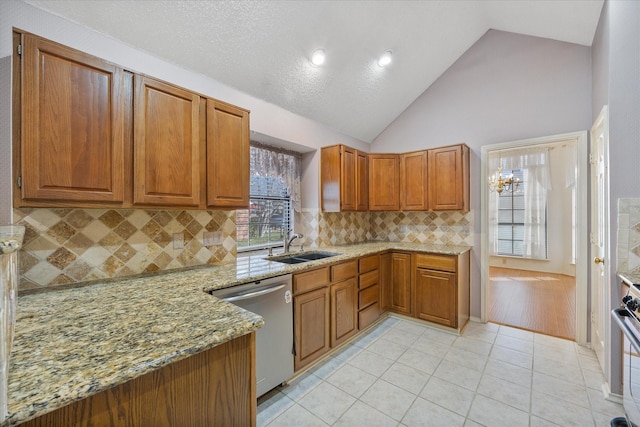 kitchen with sink, stainless steel appliances, tasteful backsplash, light stone counters, and light tile patterned floors