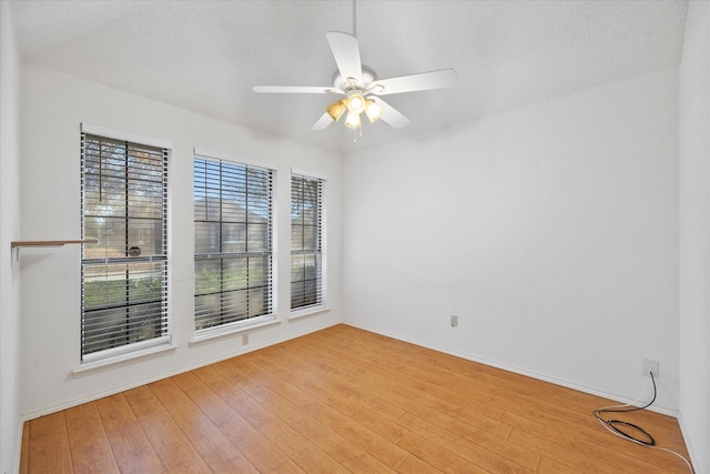 empty room featuring ceiling fan, a healthy amount of sunlight, and light wood-type flooring