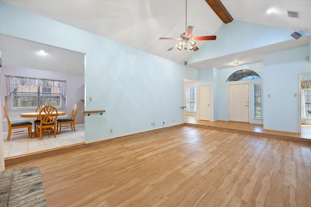 unfurnished living room featuring beamed ceiling, light hardwood / wood-style floors, high vaulted ceiling, and ceiling fan