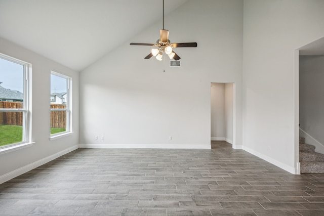 empty room with high vaulted ceiling, light hardwood / wood-style floors, and ceiling fan