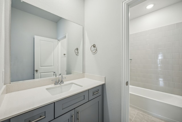 bathroom featuring tile patterned floors, vanity, and tiled shower / bath combo