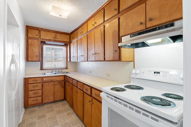 kitchen with a textured ceiling, white appliances, and sink