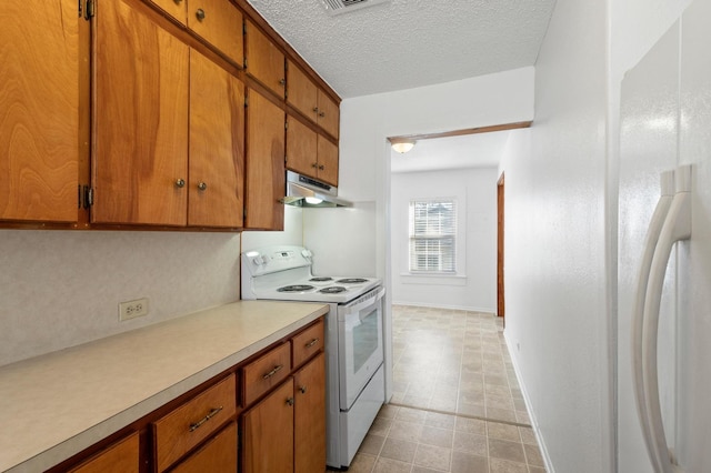 kitchen featuring white appliances and a textured ceiling