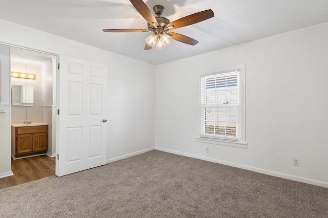 carpeted spare room with ceiling fan and sink