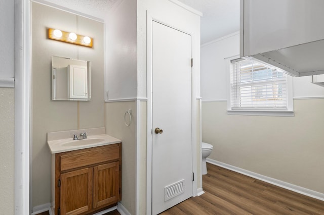 bathroom with hardwood / wood-style floors, vanity, and toilet