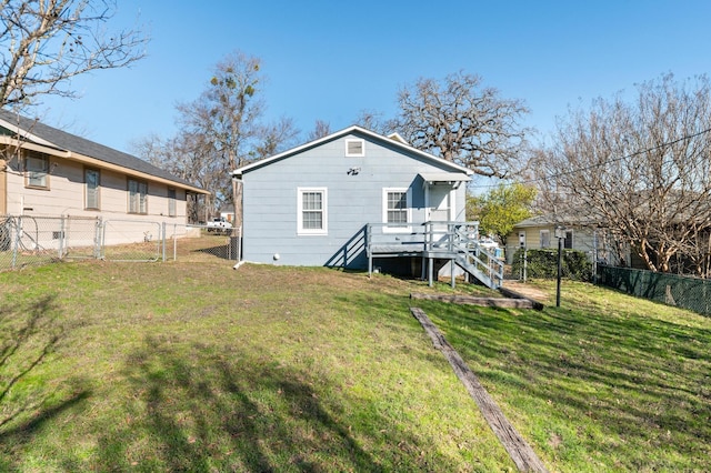 rear view of property with a yard and a deck