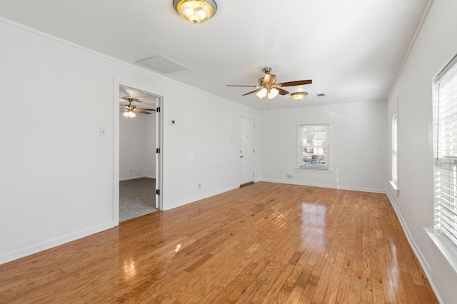 spare room featuring a healthy amount of sunlight, wood-type flooring, and ornamental molding