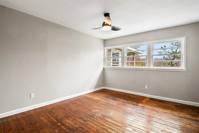 empty room with ceiling fan and dark hardwood / wood-style flooring