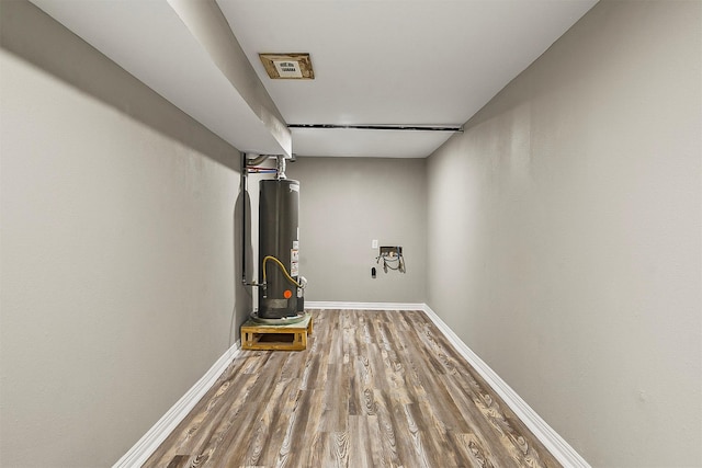 interior space with hardwood / wood-style floors and water heater