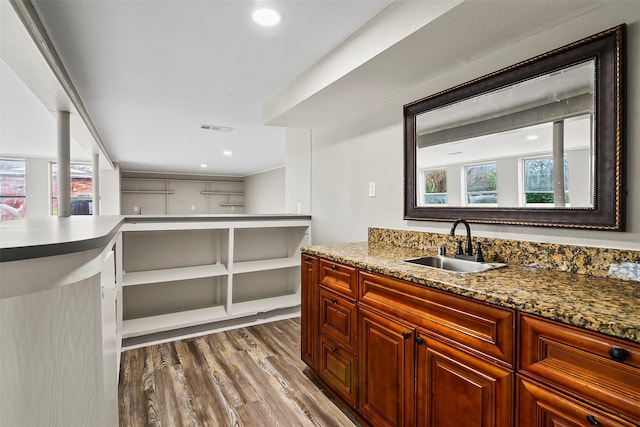 kitchen featuring light stone countertops, sink, and dark wood-type flooring