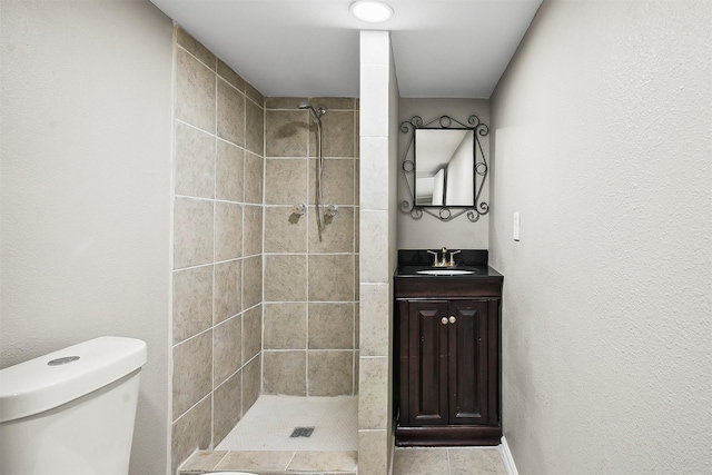 bathroom featuring vanity, tiled shower, and toilet