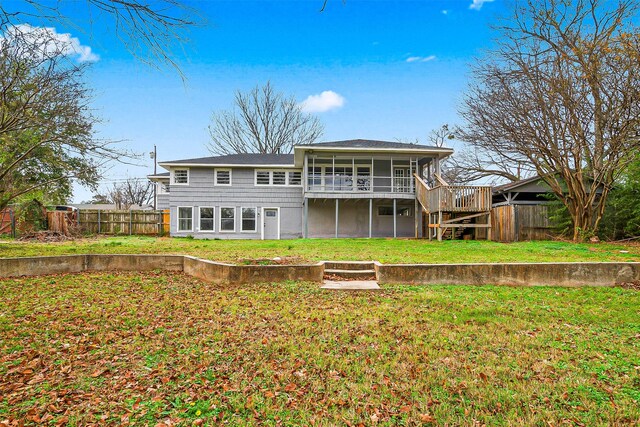 rear view of property with a sunroom, a yard, and a wooden deck