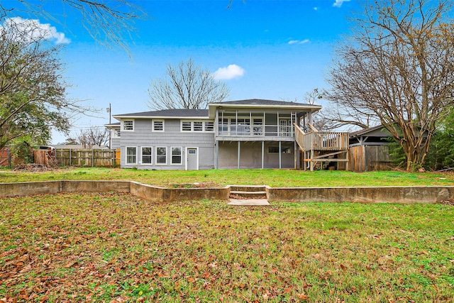 back of property with a deck and a lawn