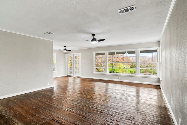 unfurnished living room with dark wood-type flooring, ceiling fan, ornamental molding, and a textured ceiling