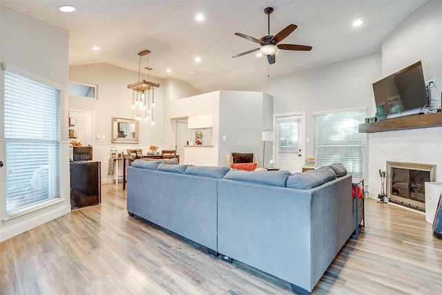 living room featuring high vaulted ceiling, light hardwood / wood-style flooring, and ceiling fan