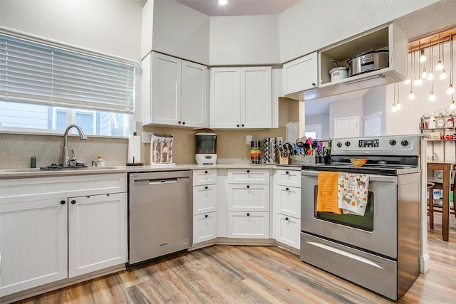 kitchen featuring sink, white cabinetry, tasteful backsplash, light wood-type flooring, and stainless steel appliances