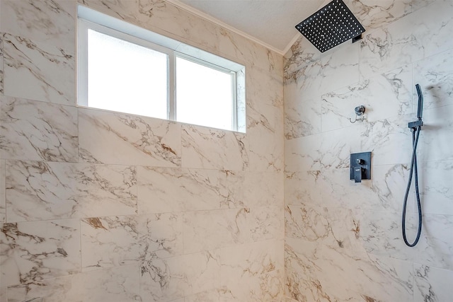 bathroom featuring a tile shower and ornamental molding