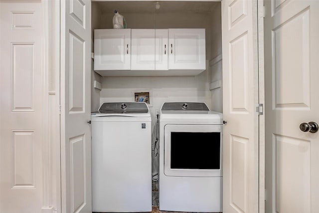 clothes washing area with cabinets and separate washer and dryer