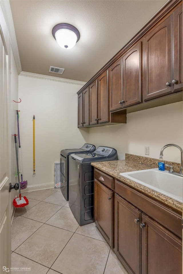 laundry area with sink, crown molding, cabinets, separate washer and dryer, and light tile patterned floors