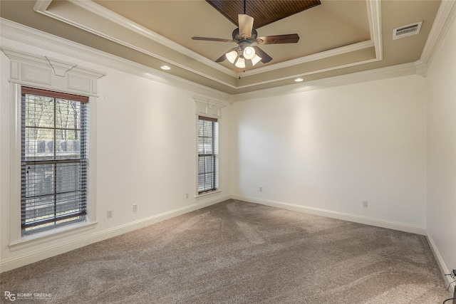 carpeted empty room featuring crown molding, a raised ceiling, and ceiling fan