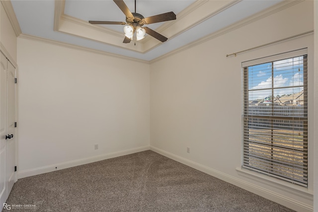 unfurnished room featuring crown molding, a tray ceiling, ceiling fan, and carpet