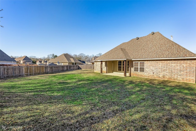 rear view of property with a yard and a patio