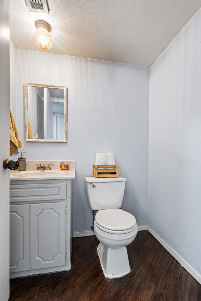 bathroom with hardwood / wood-style floors, vanity, and toilet