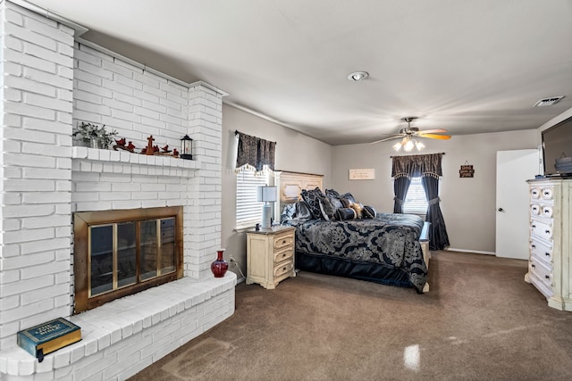 carpeted bedroom with a brick fireplace and ceiling fan