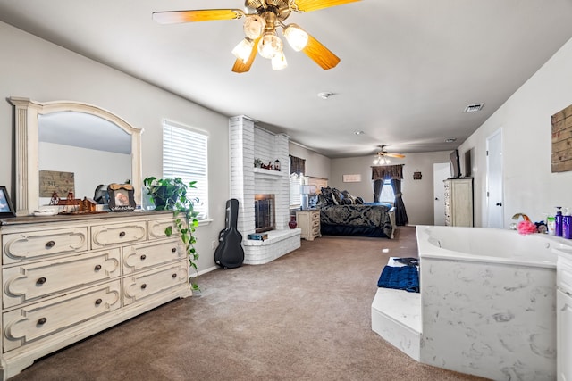 bedroom with carpet flooring, ceiling fan, a fireplace, and sink