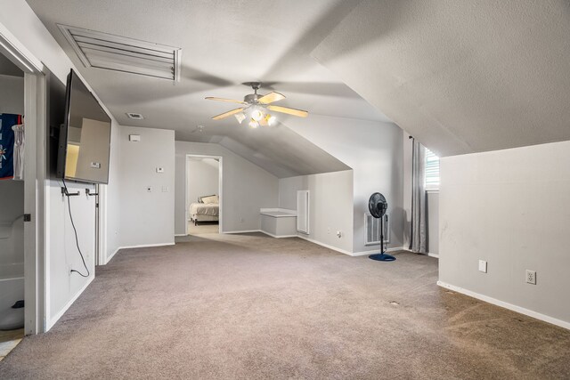 additional living space with carpet flooring, ceiling fan, a textured ceiling, and vaulted ceiling