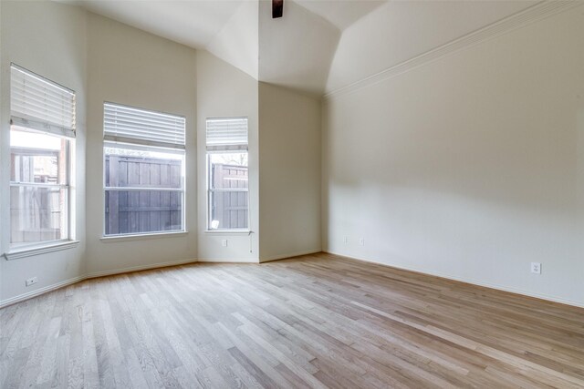 unfurnished room with a high ceiling, crown molding, ceiling fan, and light wood-type flooring