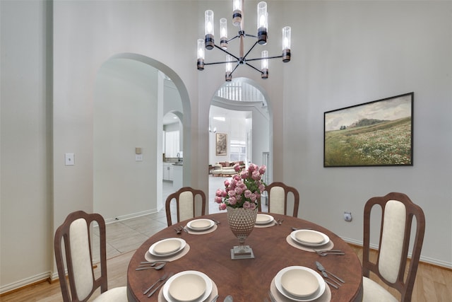 dining area with a towering ceiling and a chandelier