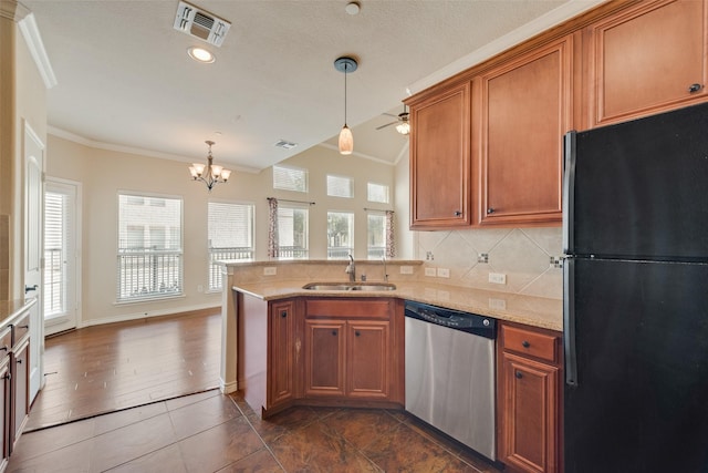 kitchen with pendant lighting, sink, black refrigerator, backsplash, and stainless steel dishwasher