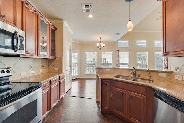 kitchen featuring ornamental molding, stainless steel appliances, sink, and hanging light fixtures