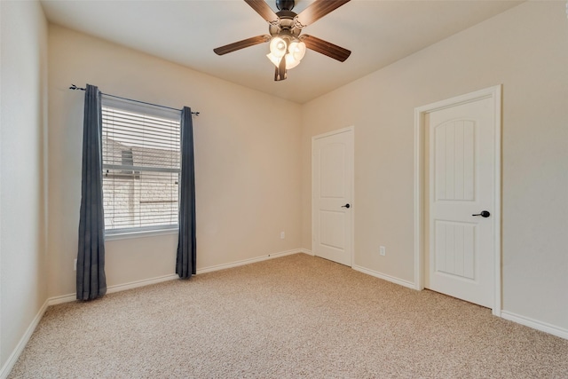 carpeted spare room with ceiling fan