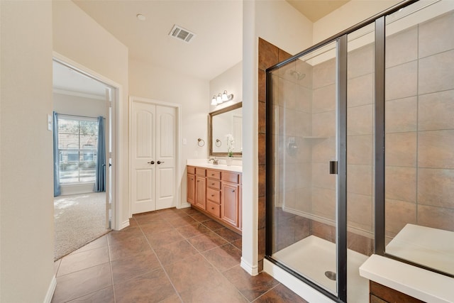 bathroom featuring walk in shower, vanity, and tile patterned flooring