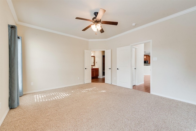 unfurnished bedroom with ensuite bath, ornamental molding, light colored carpet, and ceiling fan