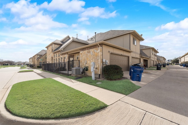 view of side of home featuring a garage and central air condition unit