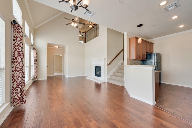 unfurnished living room with ceiling fan, ornamental molding, dark hardwood / wood-style flooring, and high vaulted ceiling