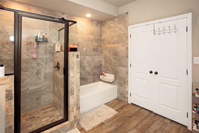 bathroom with separate shower and tub and wood-type flooring