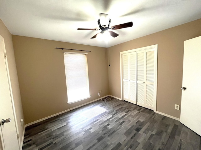 unfurnished bedroom featuring dark wood-type flooring, ceiling fan, and a closet