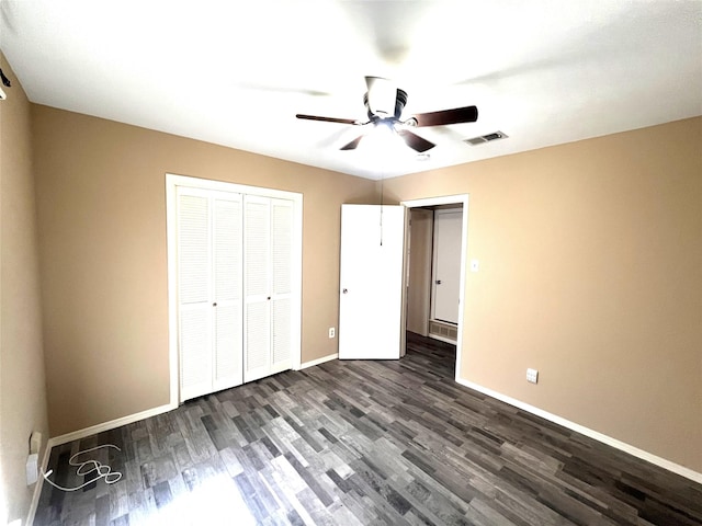 unfurnished bedroom with ceiling fan, dark hardwood / wood-style flooring, and a closet