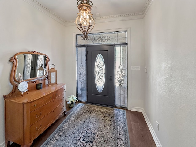 entryway with dark wood-type flooring, crown molding, and an inviting chandelier