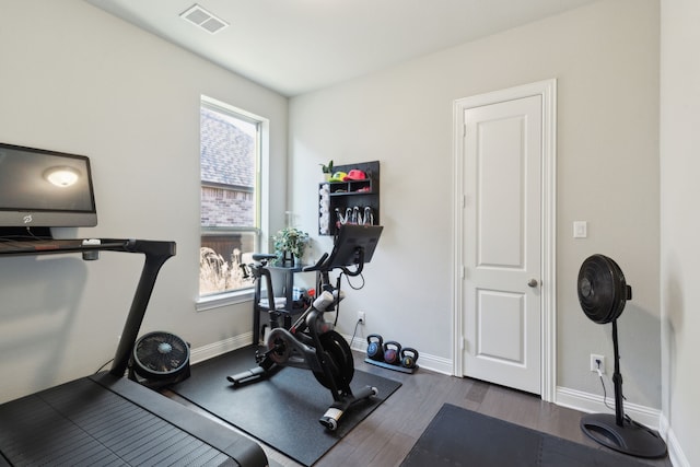 workout room featuring dark wood-style floors, baseboards, and visible vents