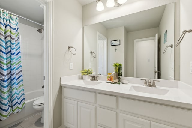 bathroom with double vanity, a sink, toilet, and shower / bath combo with shower curtain