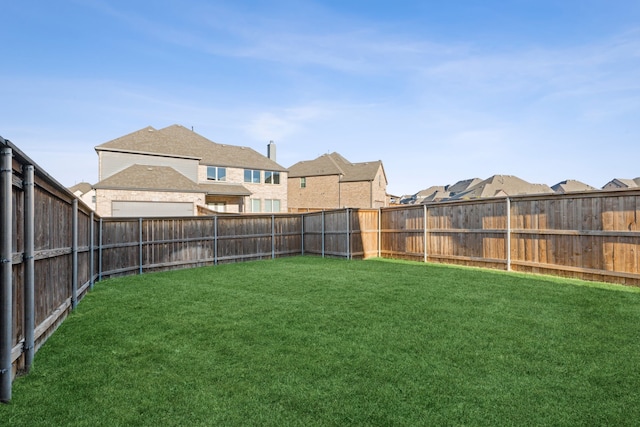 view of yard featuring a fenced backyard and a residential view