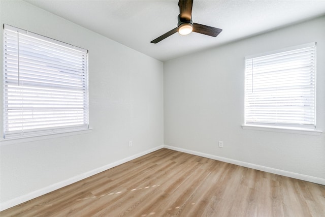 spare room with plenty of natural light, light hardwood / wood-style floors, and ceiling fan