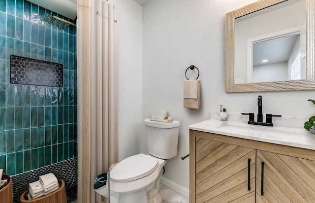 bathroom with vanity, toilet, and a tile shower