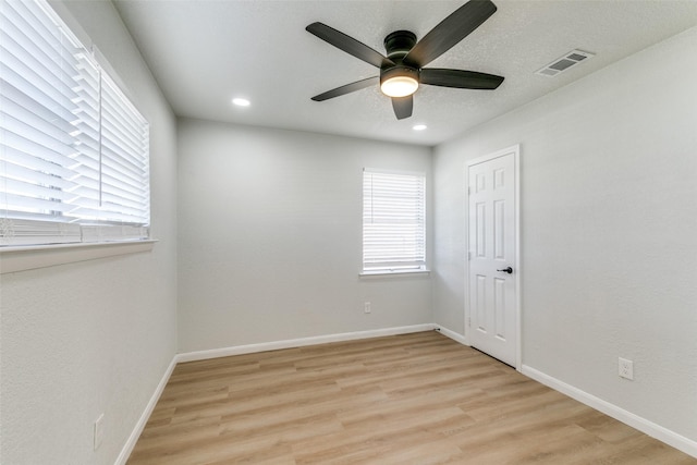 unfurnished room featuring a textured ceiling, ceiling fan, and light wood-type flooring